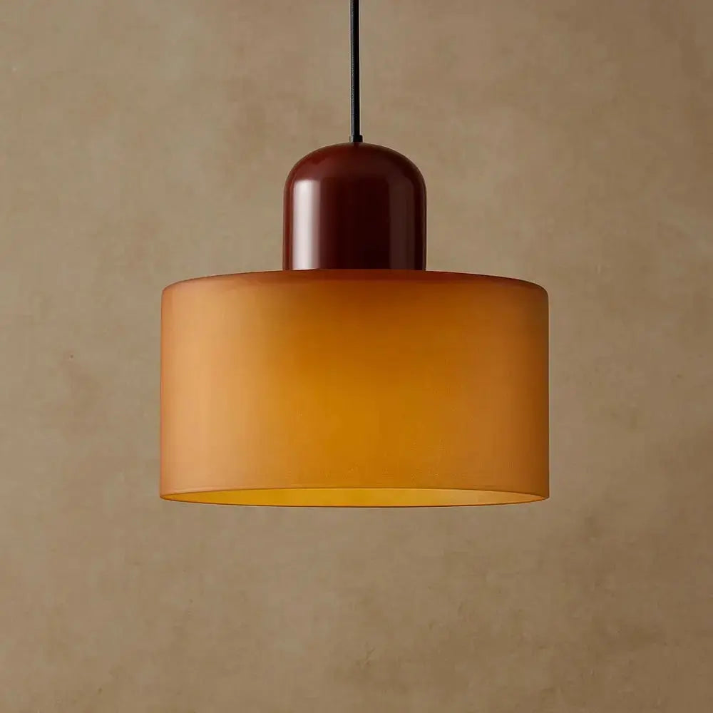 Suspension cylindrique orange au-dessus d'une table